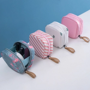 Lot de quatre petites trousses à maquillage carrées avec poignées en cuir et motifs