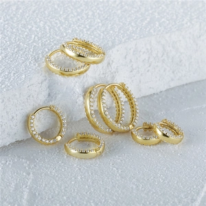 Macro detail of classic S925 silver gold-plated hoop earrings with double row zircon pavé