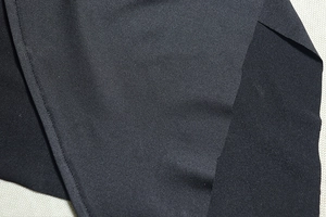 Détail du tissu noir en fibres synthétiques avec des coutures à aiguille unique