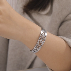 Macro detail of silver Celtic knot pattern on a stainless steel open cuff bracelet