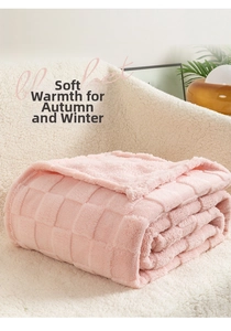 Detailed view of pink checkered fleece blanket with soft texture on a cozy sofa