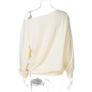 Detail view of the back of a light yellow long-sleeved cropped top with ribbed cuffs