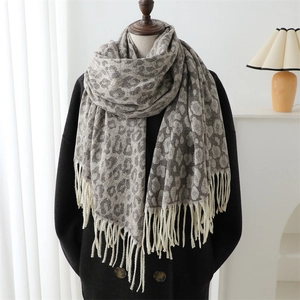 Detailed view of grey-brown leopard print scarf with soft fringe on a mannequin