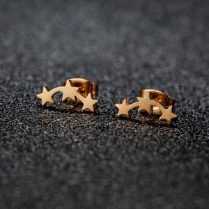 Boucles d'oreilles étoiles triples en acier doré avec un design céleste incurvé