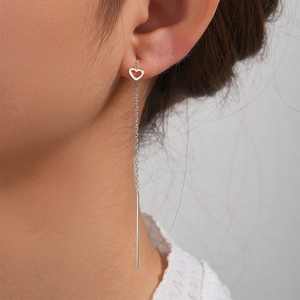 Detail of S925 silver heart tassel chain earrings worn on ear with elegant drop