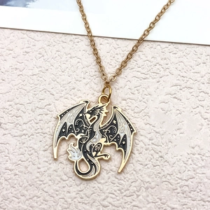 Gold dragon pendant necklace with black and white enamel star and moon pattern