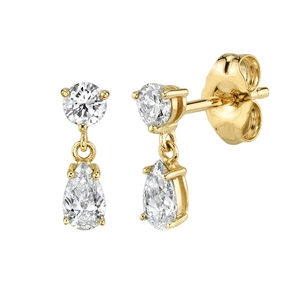 Macro view of gold drop earrings with round and pear-shaped white zircon stones