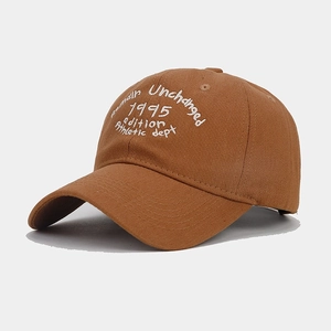 Detailed close-up of vintage brown cotton baseball cap with white athletic embroidery