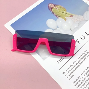 Detail view of pink Y2K children sunglasses featuring silver rivets and dark grey lens
