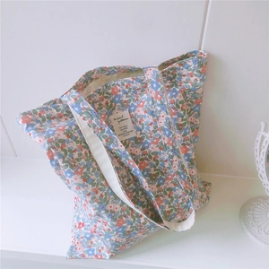Close-up of floral cotton tote bag with detailed fabric texture and animal pattern label
