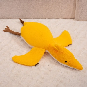 Detailed close-up of yellow plush pterosaur pillow showing soft fabric and neat stitching