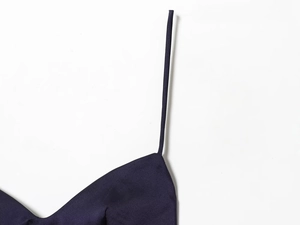 Détails macro de la robe en satin bleu marine avec fines bretelles et coutures précises