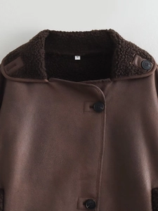 Detail of dark brown faux shearling jacket showing suede texture and large round button