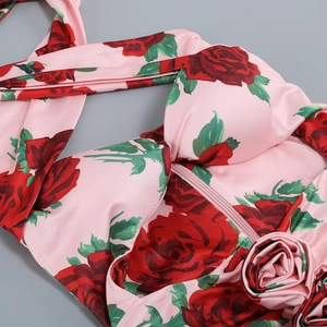 Detail of a floral halter dress featuring a 3D rose accent and hidden zipper