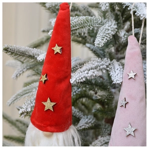 Close-up of plush Christmas gnome ornaments with gold sequins hanging on a tree