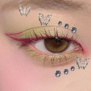 Macro view of metallic star freckle face stickers and butterfly eye makeup decoration
