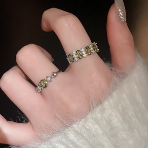 Close-up of vintage olive green oval gemstone ring set with silver band on hand