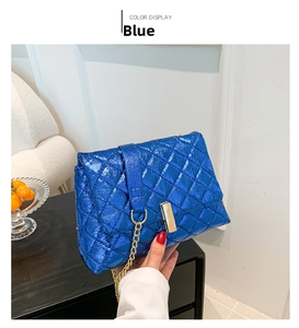 Detailed shot of the blue quilted patent leather bag with a golden metal chain and clasp
