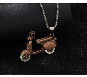 Macro shot of vintage bronze scooter pendant on silver metal chain with detailed texture