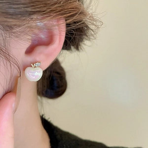 Close-up of a 3D pink pearl apple earring with sparkling crystal leaf worn on the ear