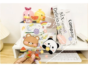 Close-up of cute cartoon stickers with bear and rainbow designs on transparent waterproof film