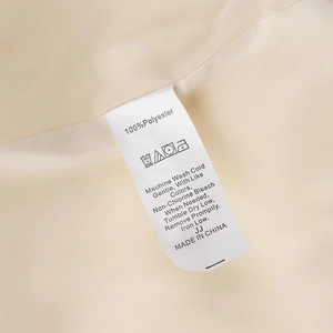 Detail shot of the garment care label showing 100% polyester fabric and washing instructions