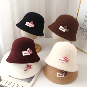 Detail of wool bucket hats in various colors with decorative polka dot bow and woven label