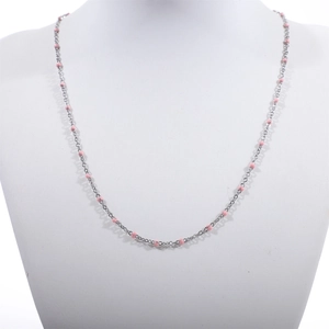 Detailed macro view of pink enamel beads on a polished silver stainless steel chain necklace