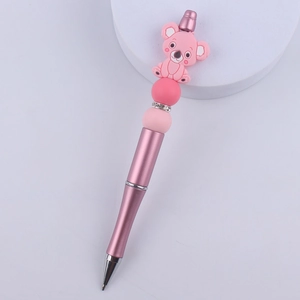 Detail of pink metal ballpoint pen with silicone koala topper and rhinestone accents