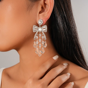 Silver bow earrings with sparkling crystal tassels on model for a luxurious look