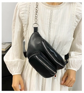 Close-up of black PU leather chest bag with silver chain strap and zipper pockets