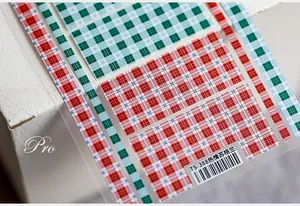 Detailed macro view of 5D Scottish plaid nail stickers in red and blue pattern
