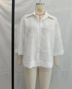 Gros plan de chemise blanche à manches courtes avec texture à franges et boutonnage