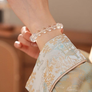 Close-up of white crystal beaded bracelet showing clear beads and natural texture