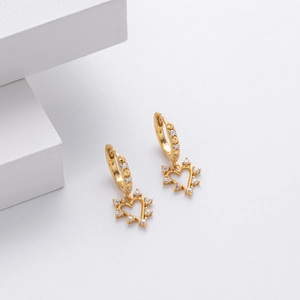 Macro view of gold heart drop earrings with sparkling cubic zirconia on stone base