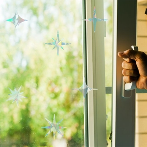 Holographic star window stickers applied on glass with rainbow prism light effect