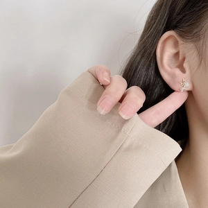 Close-up of elegant gold reindeer stud earrings with sparkling rhinestones on model