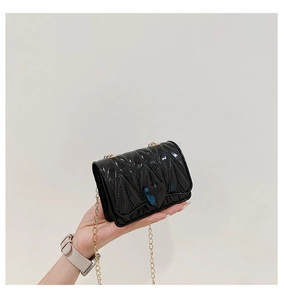 Detail of black glossy mini heart crossbody bag with V-quilting and gold chain strap