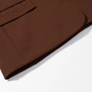 Detail view of coffee brown woven suit fabric with high-quality stitching and pocket flap