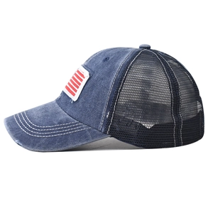 Dettaglio del cappellino in denim lavato con ricamo bandiera e retro in rete traspirante