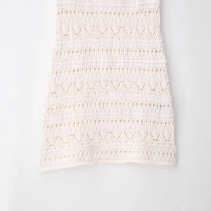 Halter crochet knit mini dress showing intricate hollow-out texture and wavy hemline