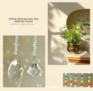 Detail of crystal suncatcher with teardrop prism and colorful glass beads for windows