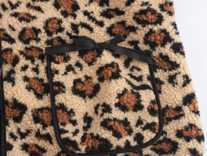 Detail of leopard print fleece jacket showing chest pocket with black bow decoration