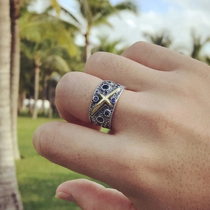 Vintage wide silver star ring with gold cross and blue zircon stones on hand outdoors