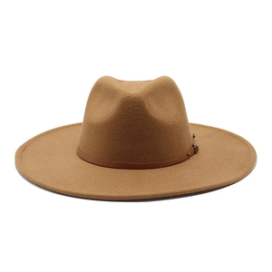 Detail of camel fedora hat featuring a wide brim and brown leather band with metal buckle