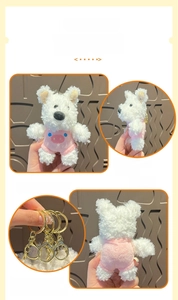 Detail view of plush Westie puppy keychain in pink outfit with golden metal ring