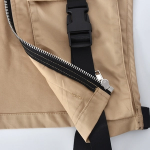 Macro view of khaki twill workwear vest featuring metal zipper and black plastic buckle