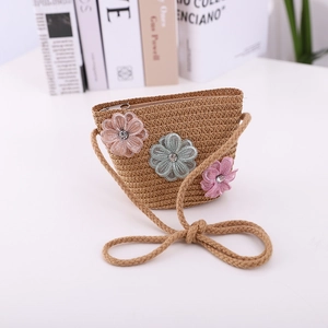 Close-up of children's straw woven crossbody bag with colorful lace flowers and zipper