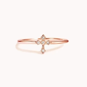 Detail of rose gold cross ring with four sparkling clear round-cut cubic zirconia stones