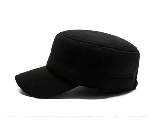 Detail view of black wool flat top military cap with golden metal side badge
